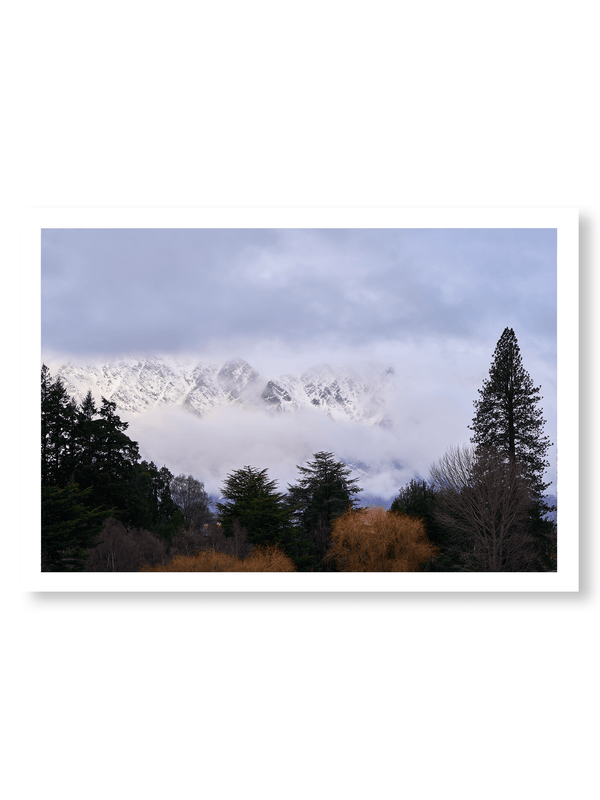 Beyond the Pines fine art landscape print featuring snow-covered New Zealand mountains and foggy alpine terrain. Moody Queenstown photography wall art, perfect for winter interiors. Premium giclée print on archival paper. Ideal for modern home décor, minimalist design, and Scandinavian-style spaces. Available from Melbourne Print Studio, part of the Snowdrift Collection.