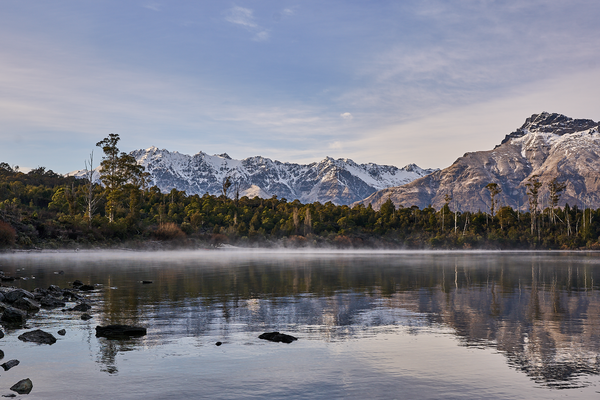Lake Haze fine art landscape print featuring snow-covered New Zealand mountains and foggy alpine terrain. Moody Queenstown photography wall art, perfect for winter interiors. Premium giclée print on archival paper. Ideal for modern home décor, minimalist design, and Scandinavian-style spaces. Available from Melbourne Print Studio, part of the Snowdrift Collection.