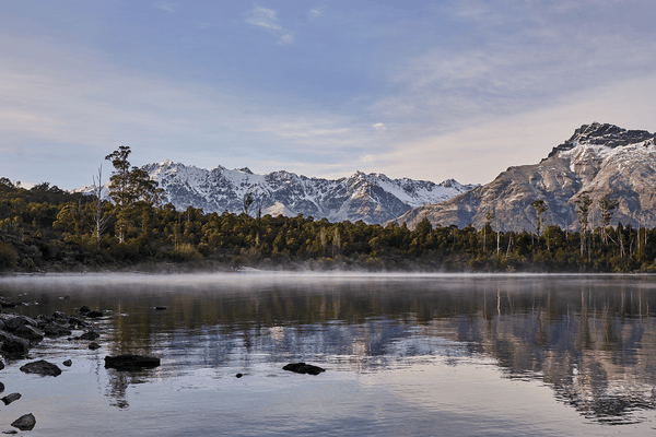 Lake Haze fine art landscape print featuring snow-covered New Zealand mountains and foggy alpine terrain. Moody Queenstown photography wall art, perfect for winter interiors. Premium giclée print on archival paper. Ideal for modern home décor, minimalist design, and Scandinavian-style spaces. Available from Melbourne Print Studio, part of the Snowdrift Collection.